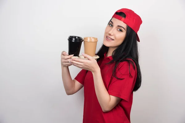 Mosolygó Piros Egyenruhában Mutatja Két Csésze Kávé Fehér Háttér — Stock Fotó