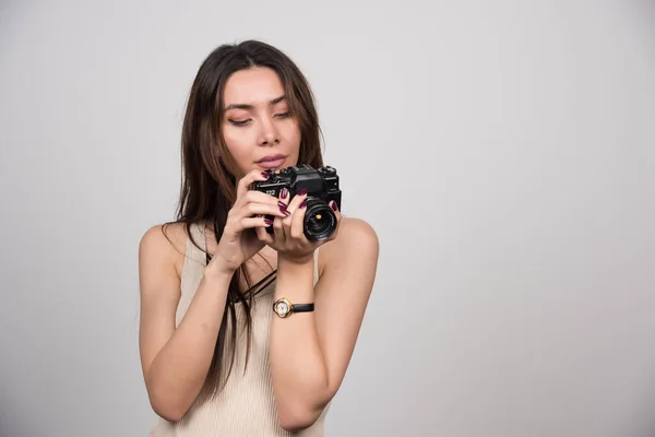 Όμορφη Γυναίκα Κοιτάζει Μια Κάμερα Γκρι Φόντο Υψηλής Ποιότητας Φωτογραφία — Φωτογραφία Αρχείου