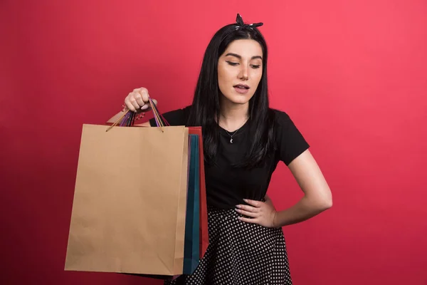 Vrouw Tonen Haar Tassen Rode Achtergrond — Stockfoto