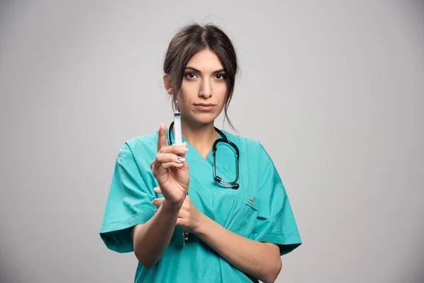 灰色の背景に注射器を持っている女性医師 高品質の写真 — ストック写真