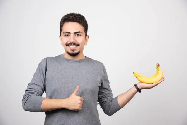 Brünettes Männchen Hält Banane Und Gibt Die Daumen Nach Oben — Stockfoto