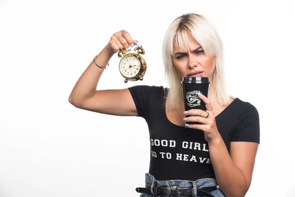 時計を持っていた若い女性は白い背景にコーヒーのカップから一口を取ります 高品質の写真 — ストック写真