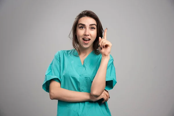 Médica Apontando Para Cima Fundo Cinza Foto Alta Qualidade — Fotografia de Stock