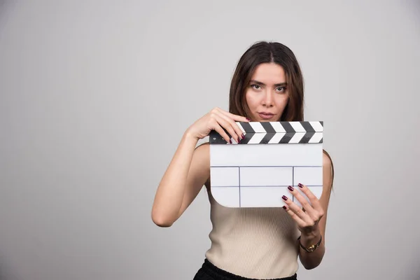 Jonge Brunette Vrouw Met Klapbord Grijze Achtergrond Hoge Kwaliteit Foto — Stockfoto