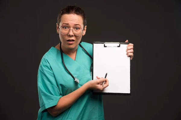 緑色の制服を着た女性看護師は患者の歴史を示し 質問をする 高品質の写真 — ストック写真
