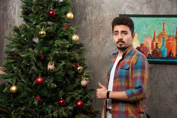 stock image Young man already decorated christmas tree. High quality photo