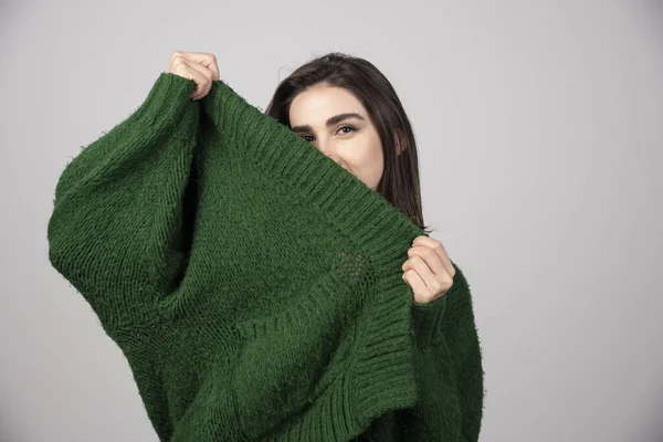 여자가 바탕에서 스웨터를 잡아당기고 있습니다 고품질 — 스톡 사진