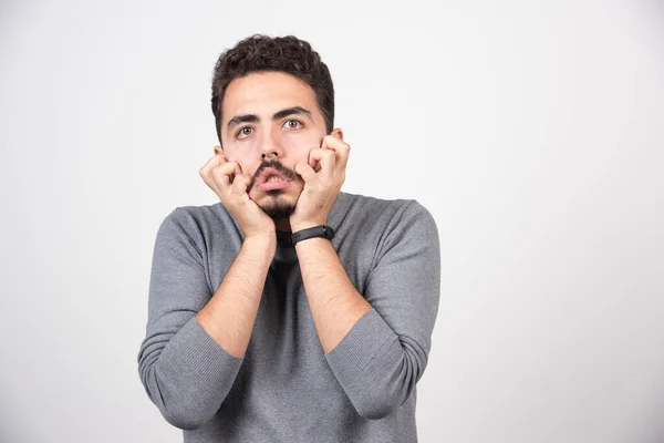 Een Jongeman Met Een Grappig Gezicht Een Witte Muur Hoge — Stockfoto