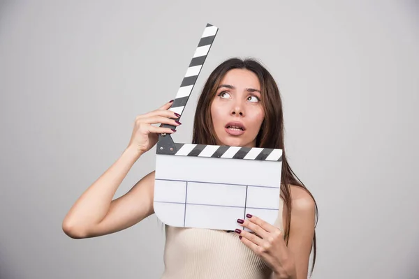 Jovem Mulher Com Clapperboard Olhando Cabeça Para Baixo Foto Alta — Fotografia de Stock