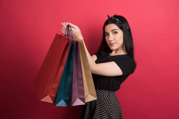 Vrouw Houden Haar Tassen Rode Achtergrond — Stockfoto