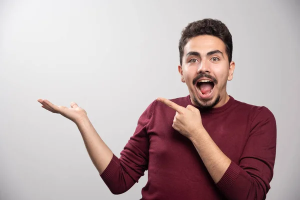 Een Lachende Brunette Die Naar Zijn Hand Wijst Hoge Kwaliteit — Stockfoto