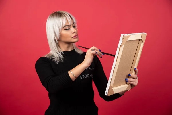 Genç Sanatçı Kadın Kırmızı Arka Planda Tuvale Resim Çiziyor Yüksek — Stok fotoğraf