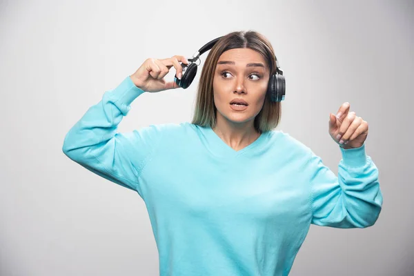 Blond Tjej Blå Tröja Som Tar Hörlurarna För Att Höra — Stockfoto