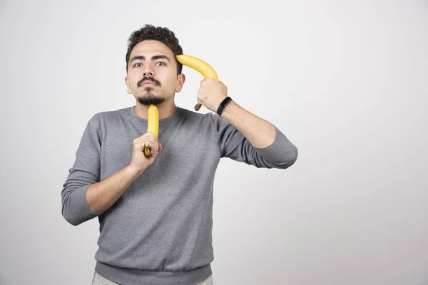 Joven Sosteniendo Dos Plátanos Frescos Foto Alta Calidad —  Fotos de Stock