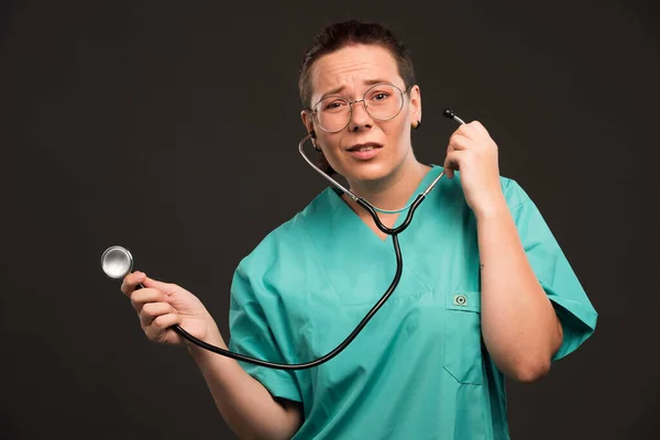 Ärztin Grüner Uniform Hält Ein Stethoskop Der Hand Und Hört — Stockfoto