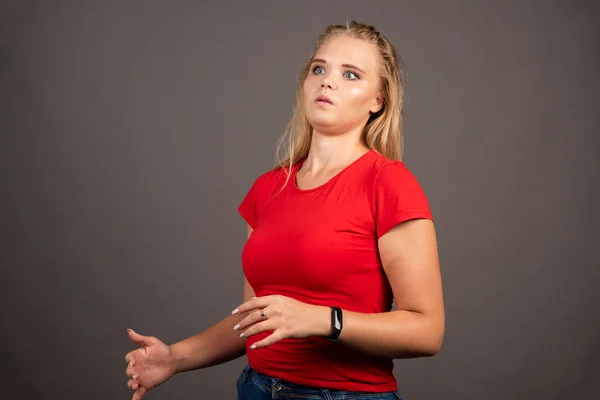 Geschokt Jonge Vrouw Rood Shirt Donkere Achtergrond Hoge Kwaliteit Foto — Stockfoto