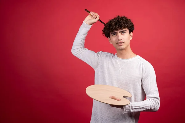 Young Male Artist Holding Palette Brushes Red Background High Quality Stock Image