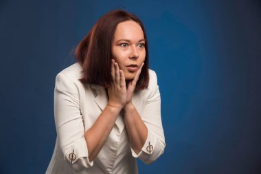 Beyaz ceketli genç bir iş kadını yüzüne bakıyor. Yüksek kalite fotoğraf