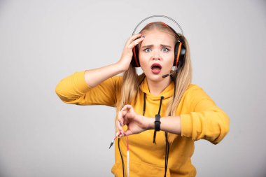 Sarı kazaklı güzel kadın zamanı görünce şaşırdı. Yüksek kalite fotoğraf