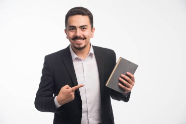 Siyah takım elbiseli bir işadamı gündemine işaret ediyor. Yüksek kalite fotoğraf