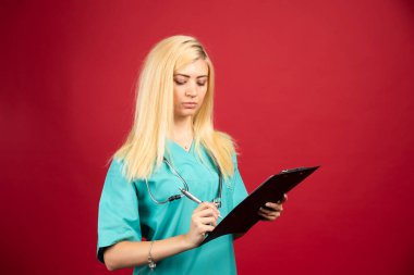 Ciddi hemşire not defterine notlar yazıyor. Yüksek kalite fotoğraf