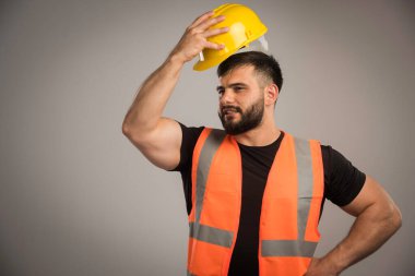 Sarı kask takan turuncu üniformalı bir mühendis. Yüksek kalite fotoğraf