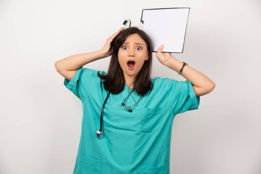 Beyaz arka planda büyüteç ve pano tutan sürpriz doktor. Yüksek kalite fotoğraf