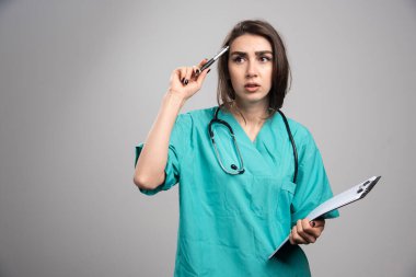 Dosyası olan kadın bir doktor ameliyat hakkında düşünüyor. Yüksek kalite fotoğraf