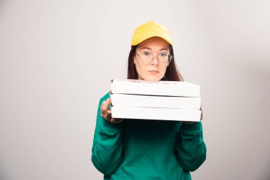 Beyaz arka planda pizza kartonlarını tutan teslimatçı kadın. Yüksek kalite fotoğraf