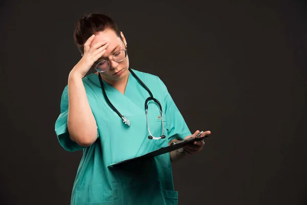 ブランクと思考を保持緑の制服の女性看護師 高品質の写真 — ストック写真
