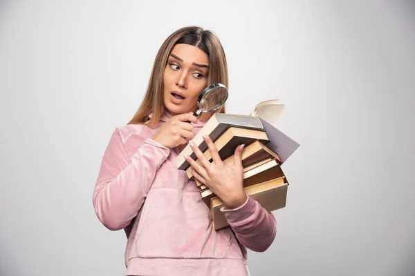 Flicka Rosa Swaetshirt Håller Ett Lager Böcker Och Försöker Läsa — Stockfoto