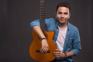 Gitarist karanlık arka planda gitar tutuyor. Yüksek kalite fotoğraf