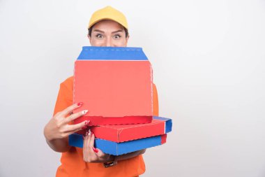 Beyaz arka planda pizza kutularını tutan teslimatçı kadın. Yüksek kalite fotoğraf