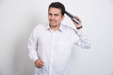 Kafası karışmış iş adamı beyaz arka planda duruyor. Yüksek kalite fotoğraf