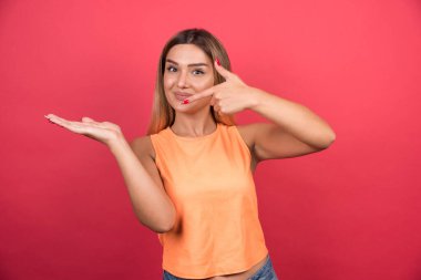 Güzel genç bir kadın elini kırmızı arka planda gösteriyor. Yüksek kalite fotoğraf