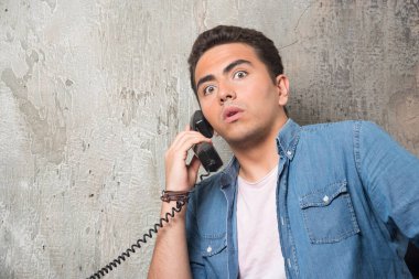 Şok olmuş bir adamın telefonla konuşurken ve sandalyede otururken fotoğrafı. Yüksek kalite fotoğraf