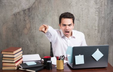 Sinirli iş adamı büro masasında telefonla konuşuyor. Yüksek kalite fotoğraf