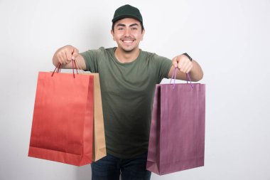 Beyaz arka planda alışveriş torbaları tutan mutlu adam. Yüksek kalite fotoğraf