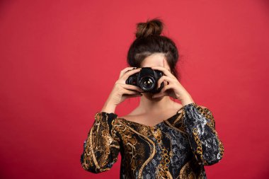 Esmer kız elinde profesyonel bir dslr kamera tutuyor ve fotoşopesyon yapıyor. Yüksek kalite fotoğraf