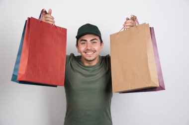 Beyaz arka planda alışveriş torbaları olan genç bir adam. Yüksek kalite fotoğraf