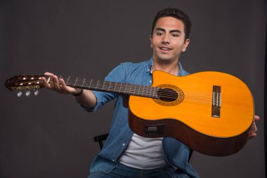 Gitarist karanlık arka planda gitar çalıyor. Yüksek kalite fotoğraf