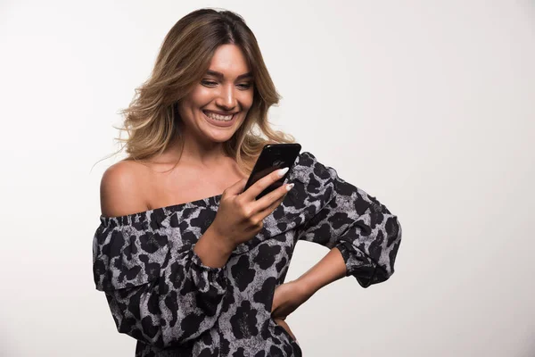 Młoda Kobieta Śmieje Się Patrząc Telefon Białym Tle Wysokiej Jakości — Zdjęcie stockowe