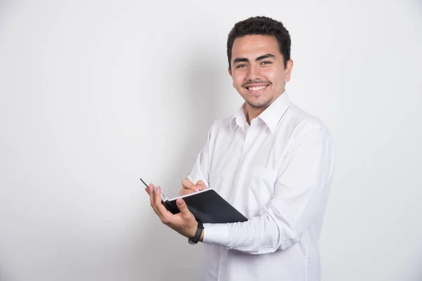 Empresário Com Caderno Sorrindo Fundo Branco Foto Alta Qualidade — Fotografia de Stock