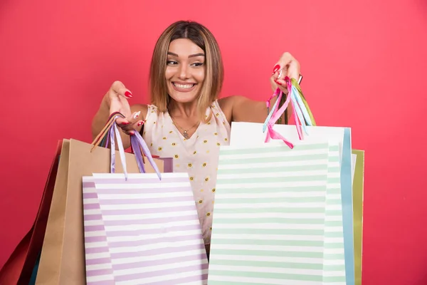 Vrouw Met Boodschappentassen Met Vrolijke Uitdrukking Rode Achtergrond Hoge Kwaliteit — Stockfoto