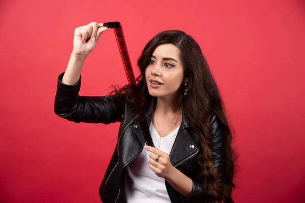 Jovem Olhando Uma Fita Fotográfica Fundo Vermelho Foto Alta Qualidade — Fotografia de Stock