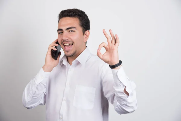 Zakenman Praat Met Mobiele Telefoon Toont Teken Witte Achtergrond Hoge — Stockfoto