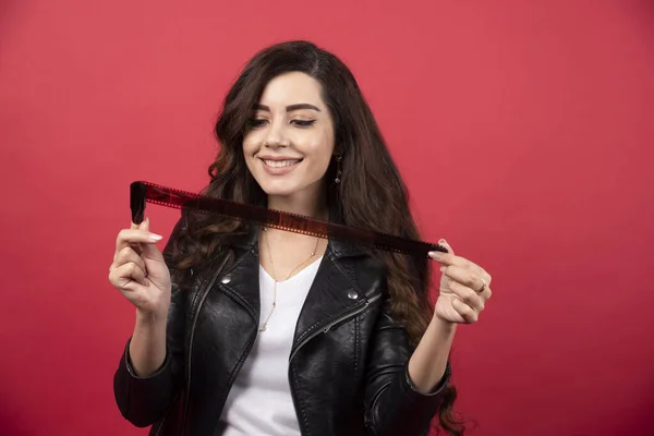 Jovem Olhando Uma Fita Fotográfica Fundo Vermelho Foto Alta Qualidade — Fotografia de Stock