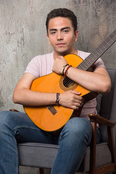 Joven Músico Abrazando Guitarra Sobre Fondo Mármol —  Fotos de Stock
