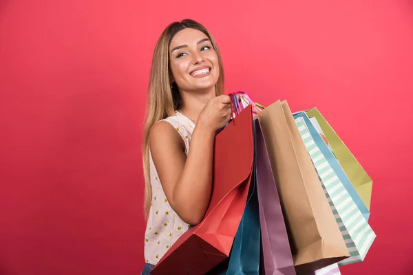 Vrouw Met Boodschappentassen Met Vrolijke Uitdrukking Rode Achtergrond Hoge Kwaliteit — Stockfoto