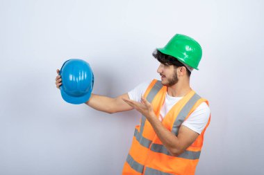 Beyaz arka planda şapkası olan genç bir inşaat işçisi. Yüksek kalite fotoğraf